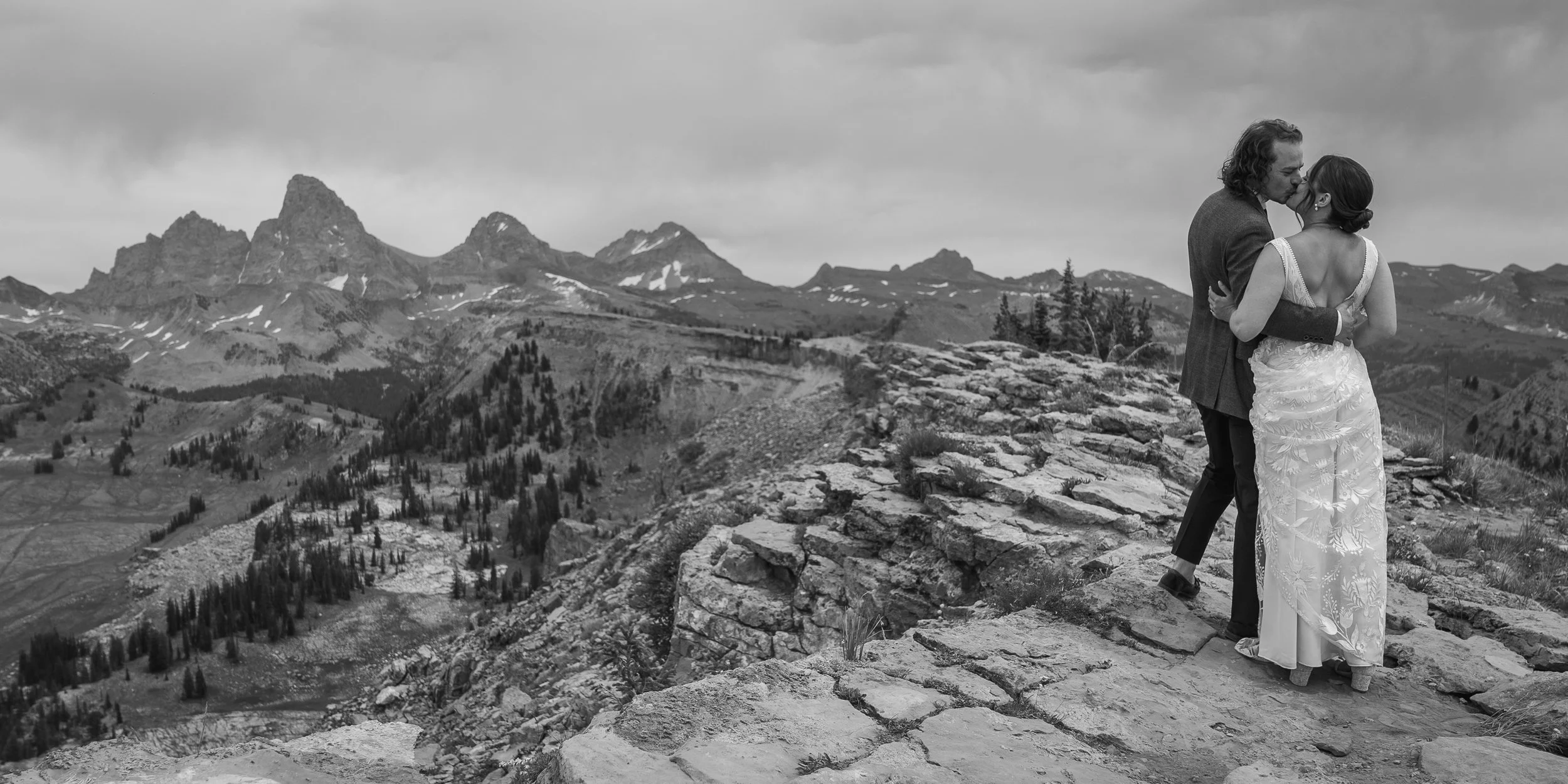 Grand Targhee Resort, documentary Wedding photography; bride and groom kiss with views of the Teton Mountain Range in the background