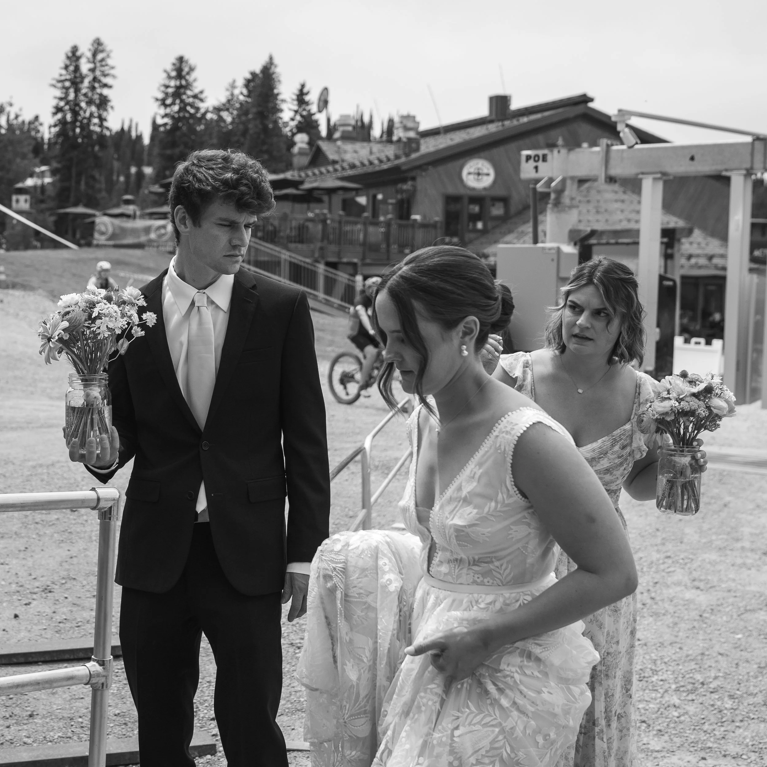 Grand Targhee Resort, Documentary wedding photography, bride with groom's brother and sister in line at ski lift, siblings holding mason jars with flower bouquets
