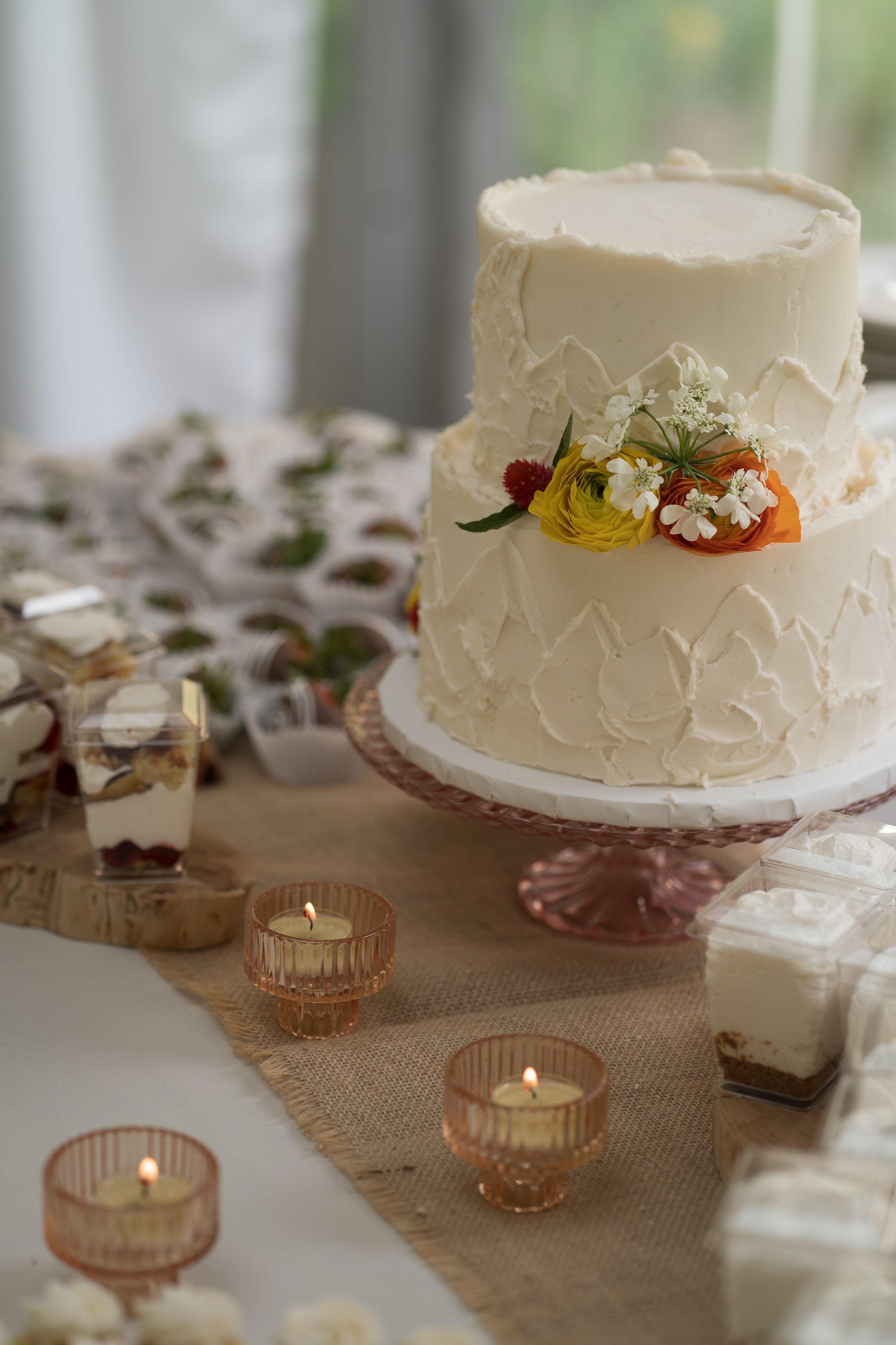 Grand Targhee Resort, documentary Wedding photography; white wedding cake with orange and yellow flowers, candles