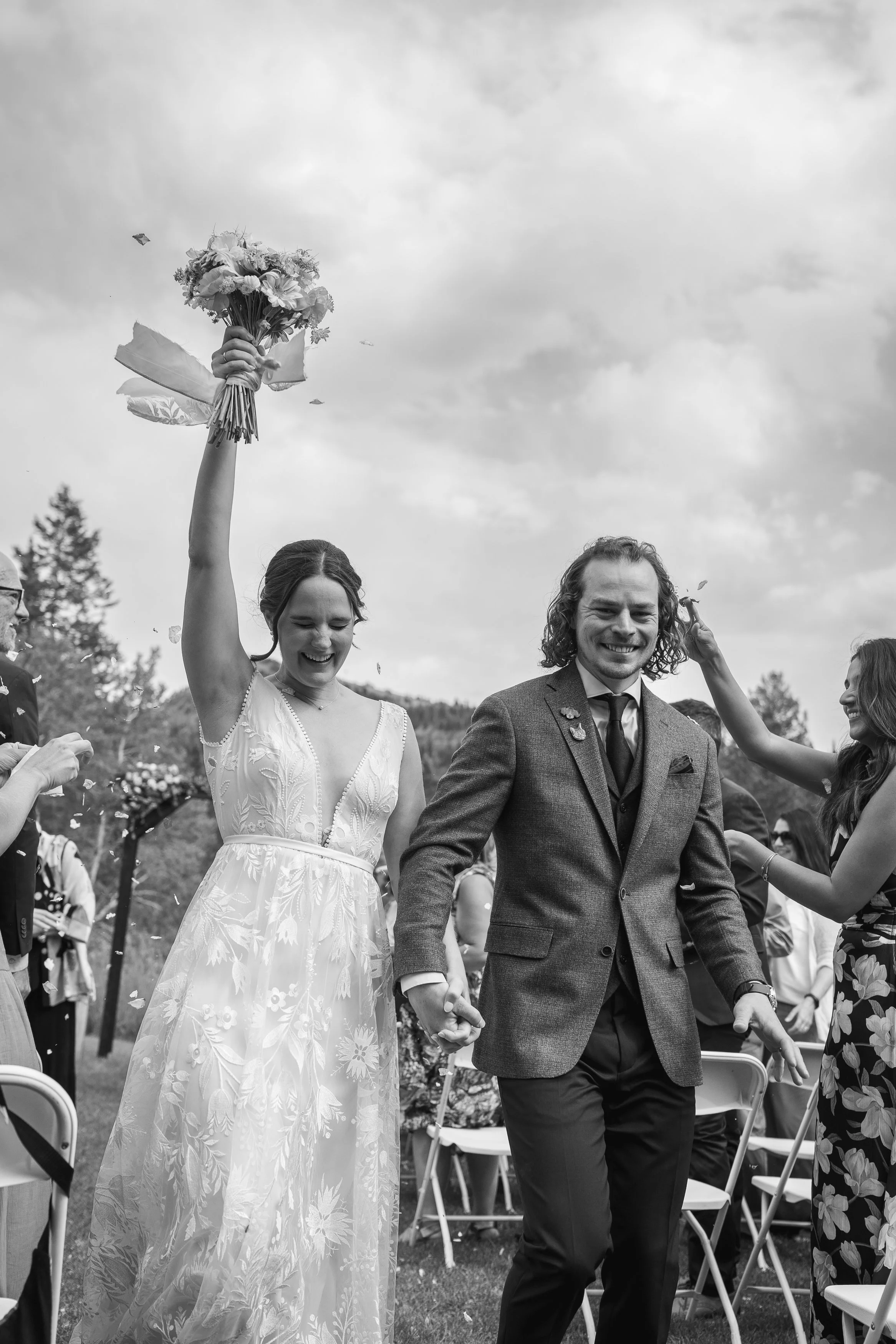 Grand Targhee Resort, documentary Wedding photography; low shot of couple with arms up walking down the aisle as confetti is being thrown at them