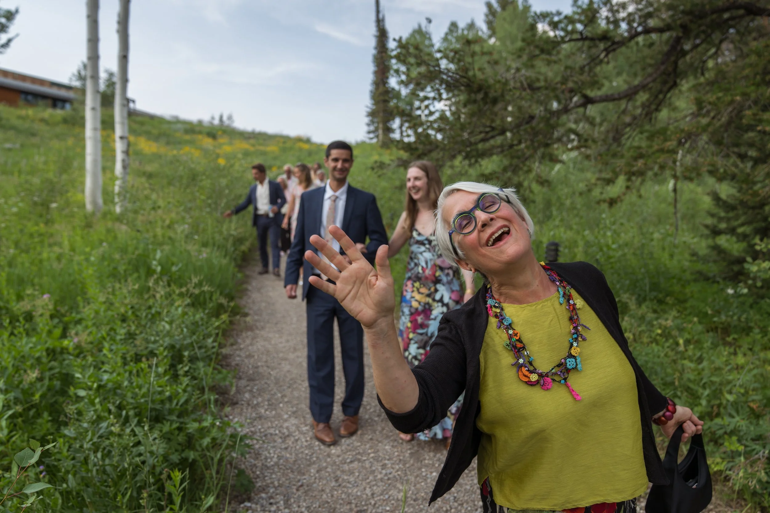 Grand Targhee Resort, documentary Wedding photography; guest waves at camera on the way to reception tent