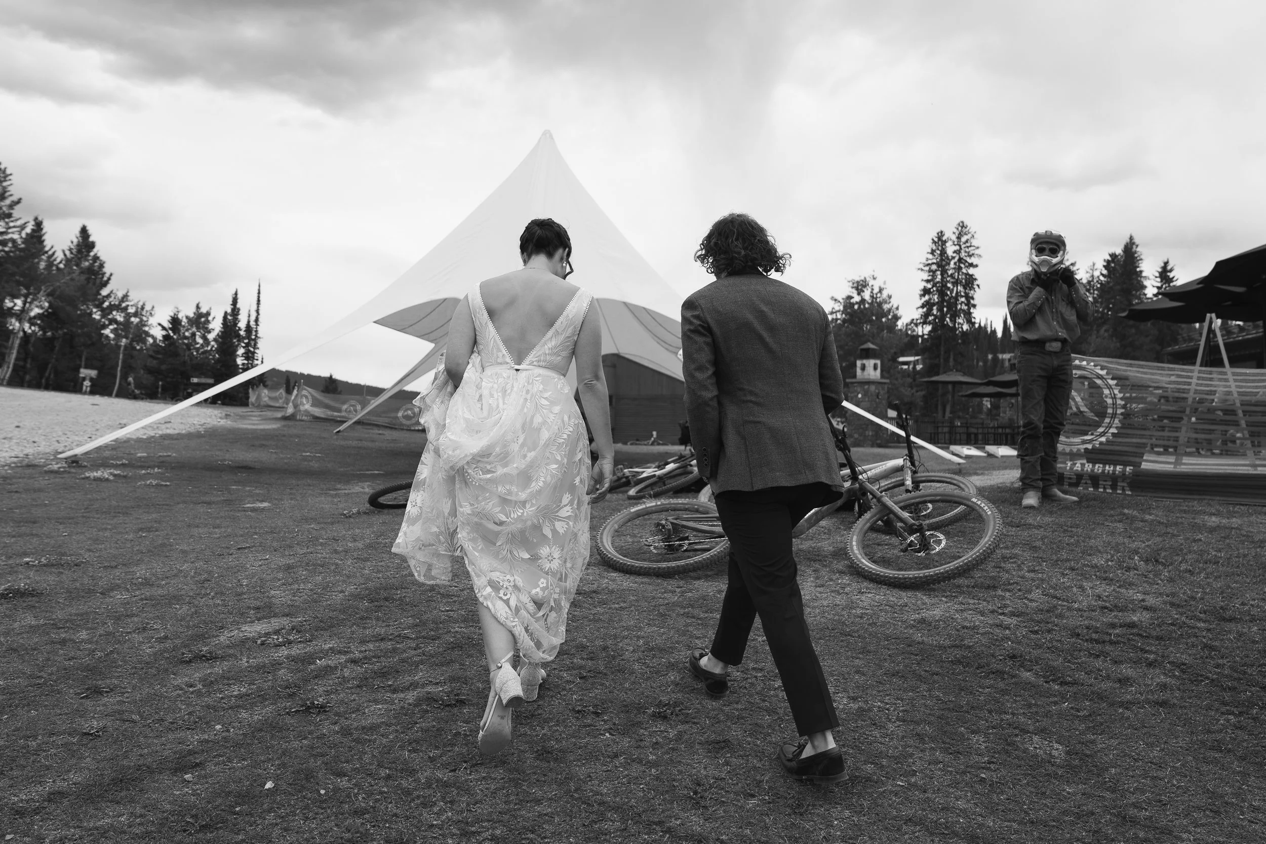 Grand Targhee Resort, documentary Wedding photography; bride and groom walk past mountain biker