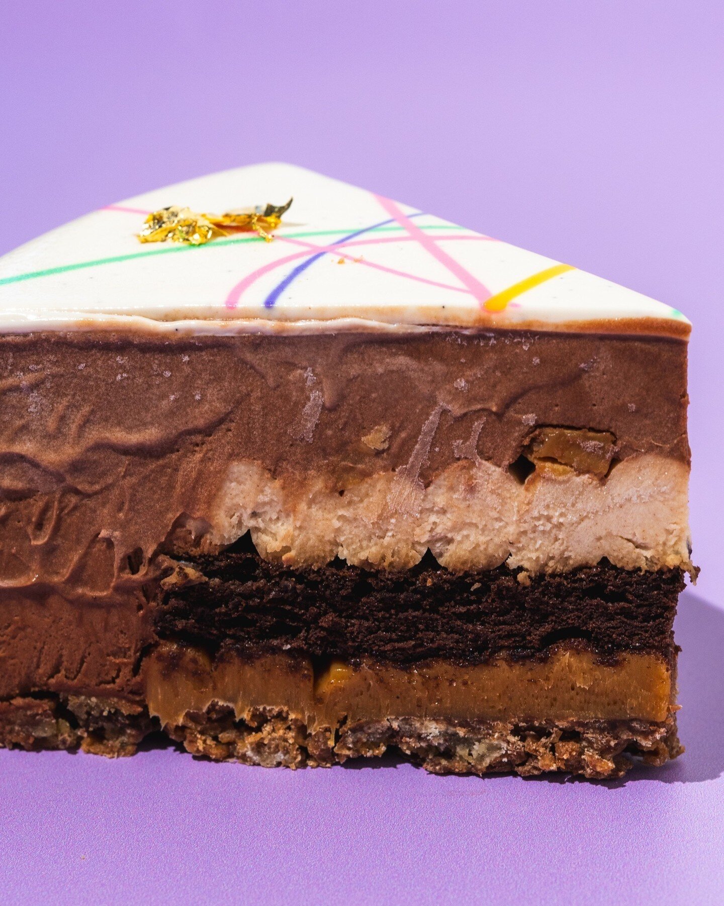 Springtime Rocky Road ~ decadent layers of caramel chocolate crumble, salted caramel, espresso sponge, almond espresso cremeux, almond and milk chocolate mousse, topped with a colourful, springtime glaze. Available by the slice or whole cake through 