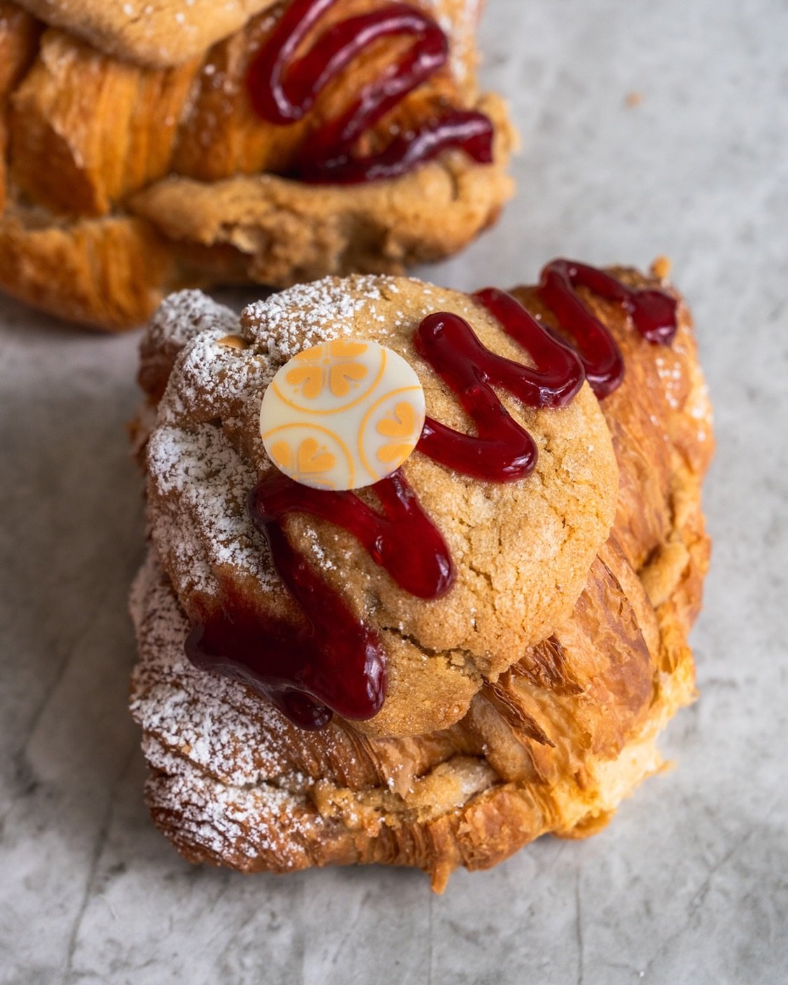Our peanut butter and jelly sandwich cookie has been transformed into the PBJ cookie croissant featuring the classic butter croissant with peanut butter cookie dough, raspberry jam, and a light dusting of icing sugar.

#bakery #dishedvan #yvreats #va