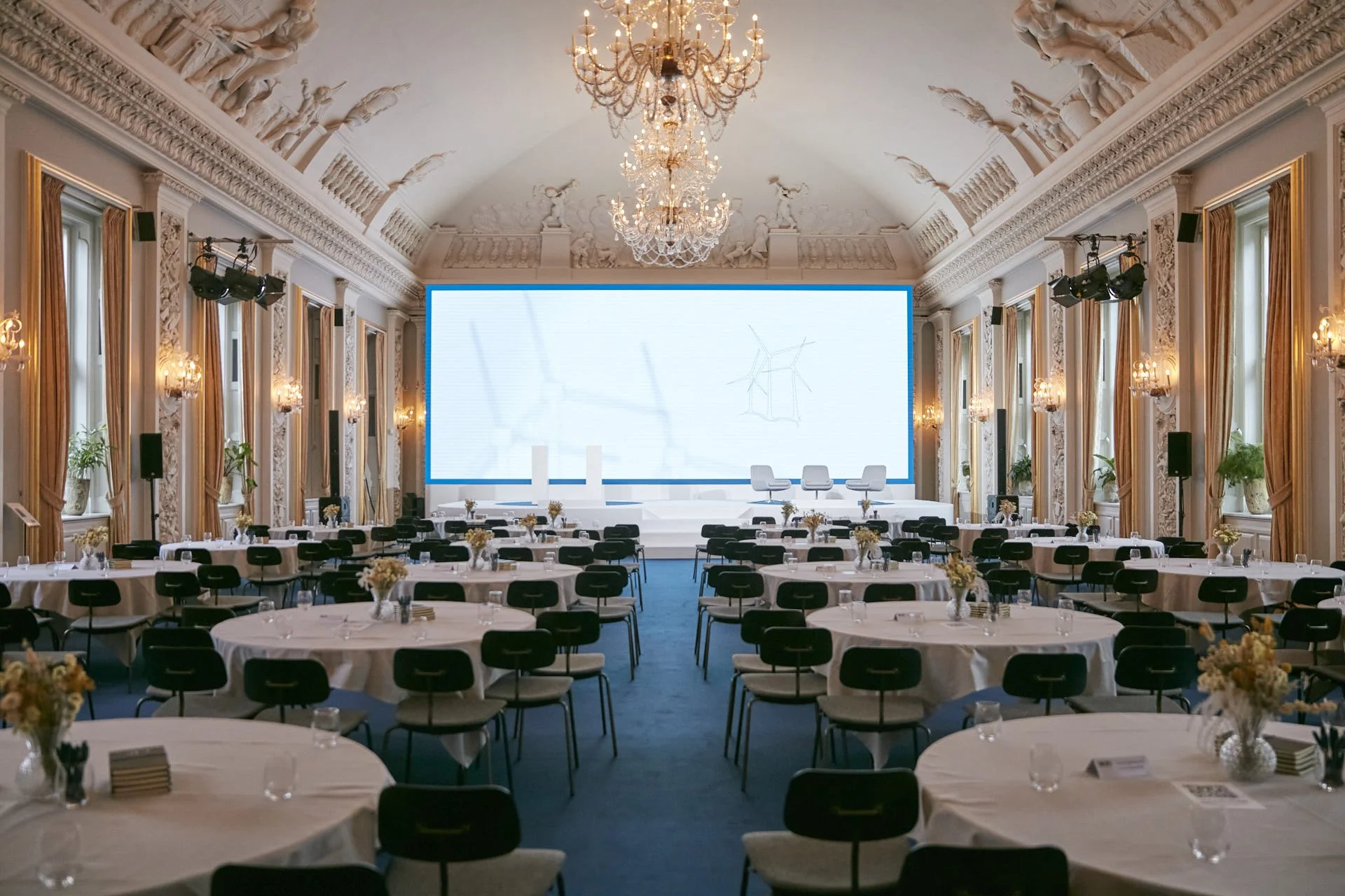 Konference i Store Festsal i Moltkes Palæ med runde borde og skærm