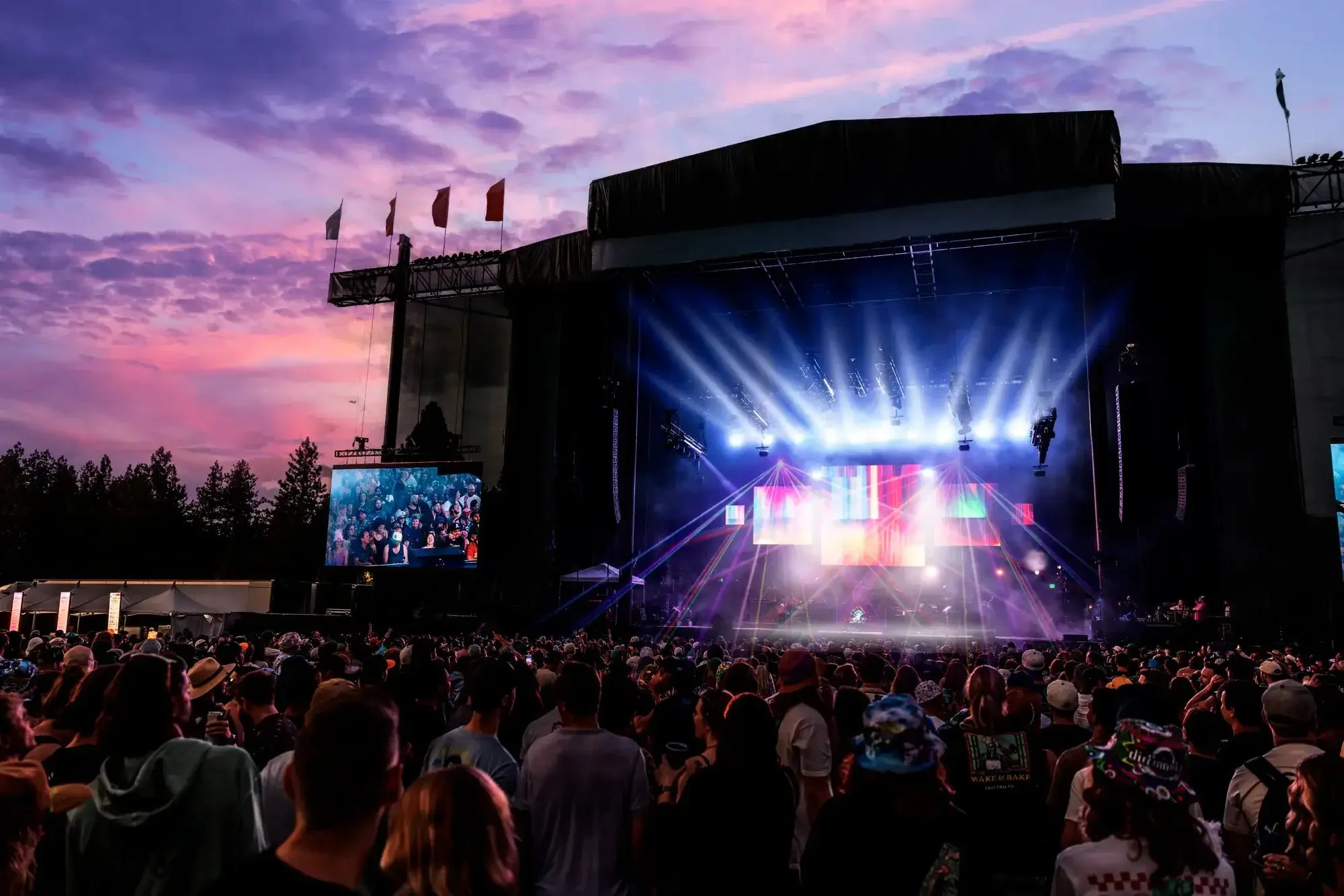 Crowd watches a concert at the Lake Tahoe Amphitheatre at Caesars Republic beneath a purple sunset.