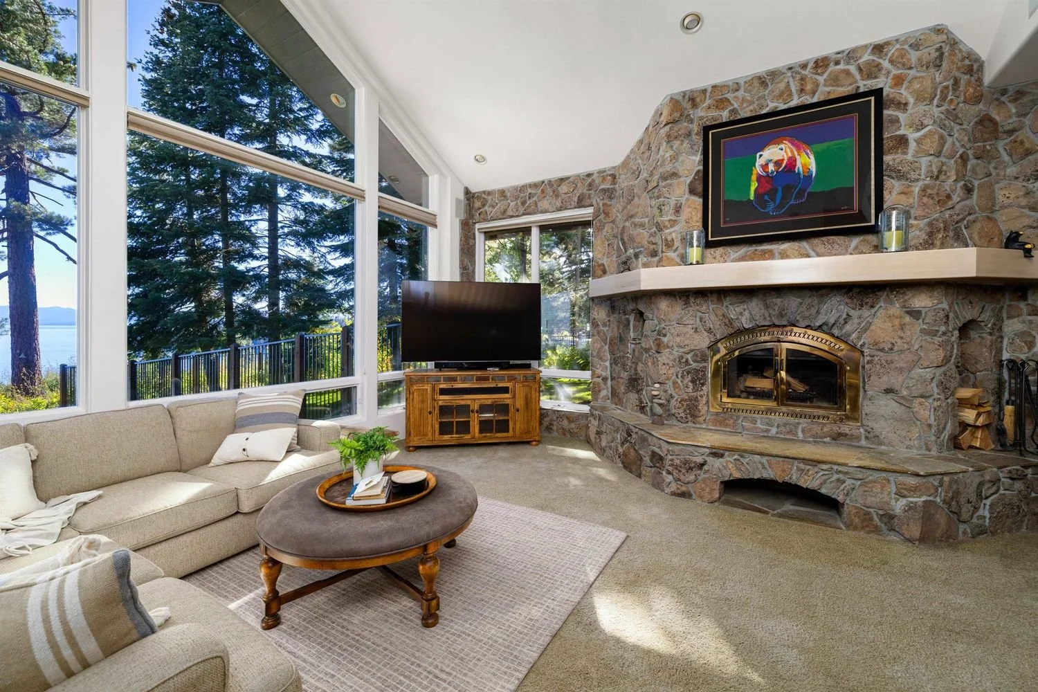 Interior living room with stone fireplace and lake-facing windows at 200 Rim Dr in Tahoe Vista, per the listing.