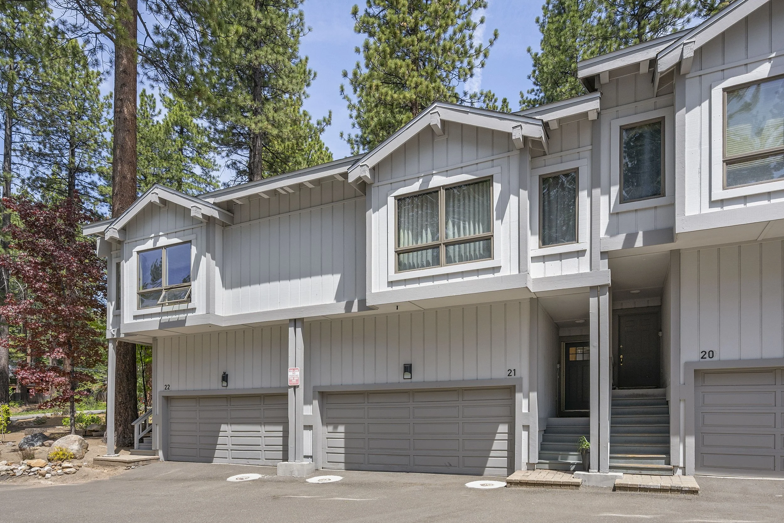 Gray board-and-batten condominium building at 908 Harold Drive with Unit 21's garage at center