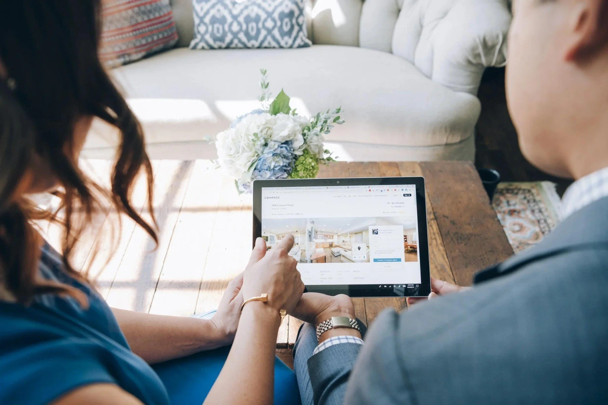A buyer and real estate professional reviewing a residential property listing on a tablet.