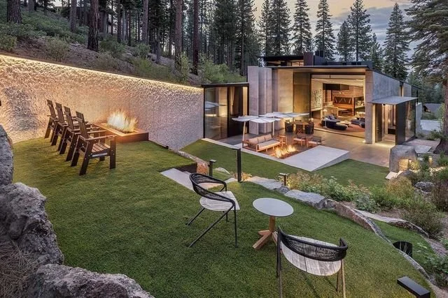 Wide view of a lit outdoor courtyard with extended seating at dusk.