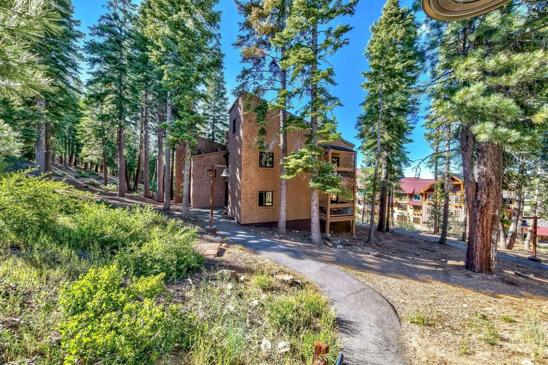 Exterior of the Ski Trails condominium building at 4002 Ski View among pines near the Village at Northstar.