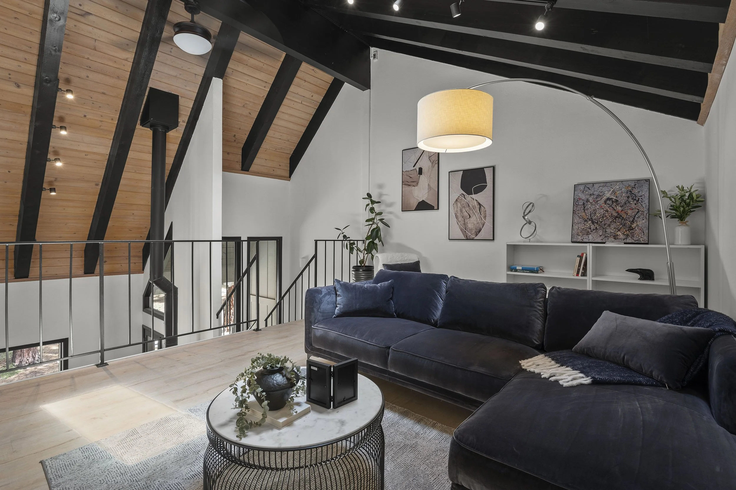 Loft-style flex room inside Unit 21 with a beamed vaulted ceiling and an open railing to the level below
