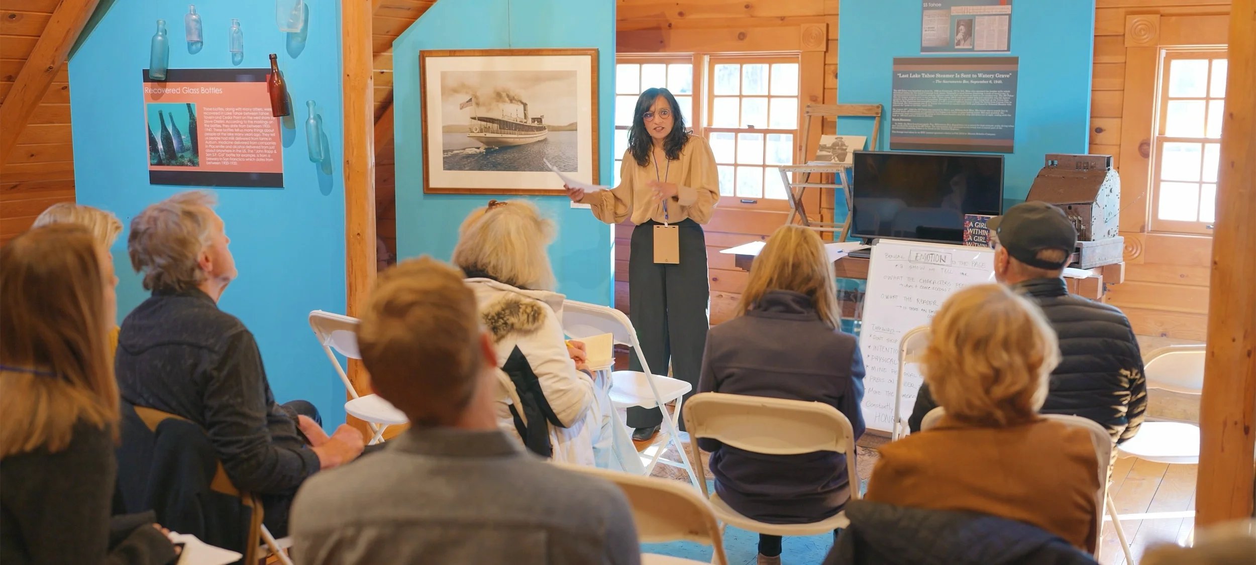 A speaker addresses a seated audience in a wood-trimmed room at the Tahoe Literary Festival.