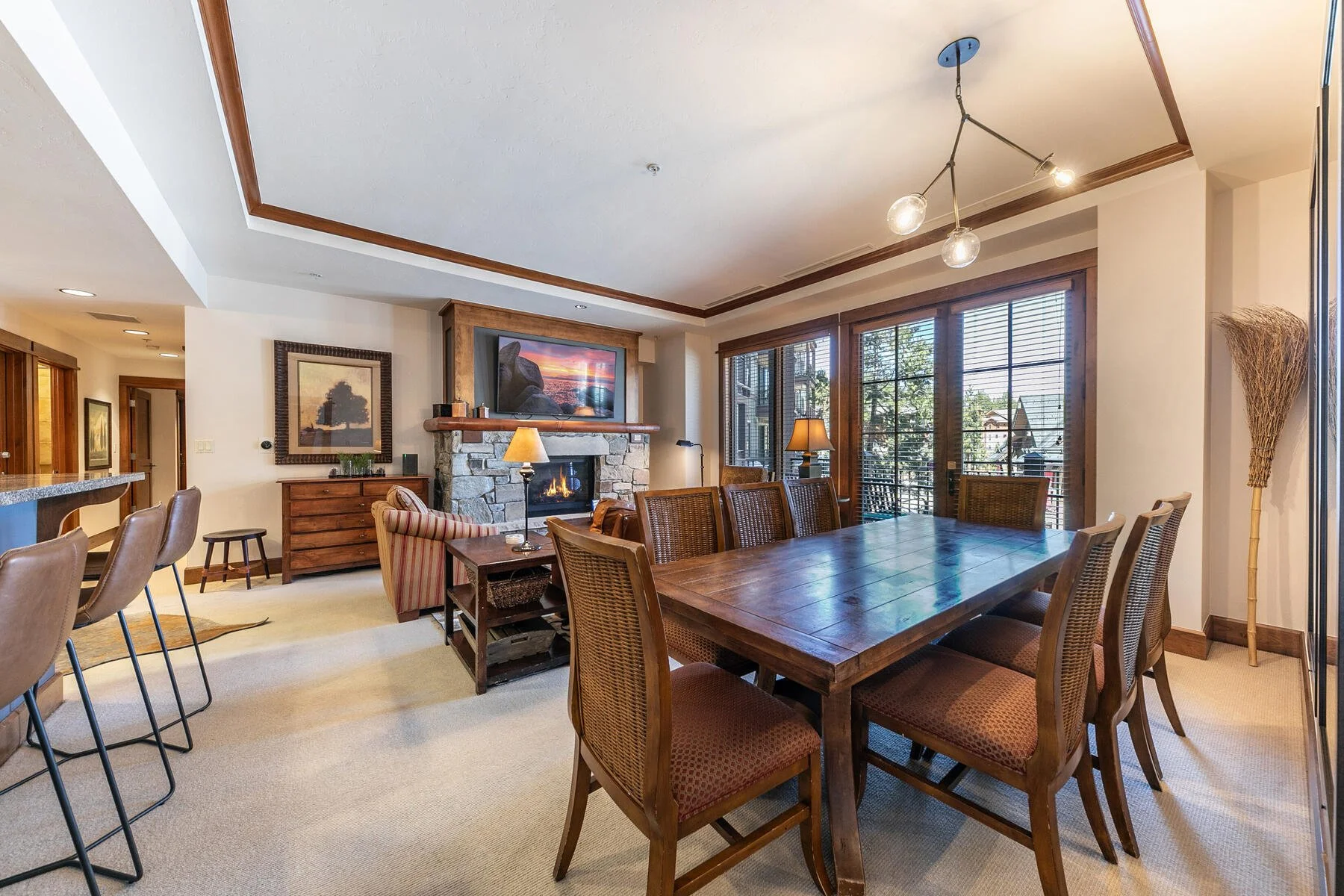 Open dining and living area at 4001 Northstar Drive Unit 209 with a stone fireplace and Village-facing windows.