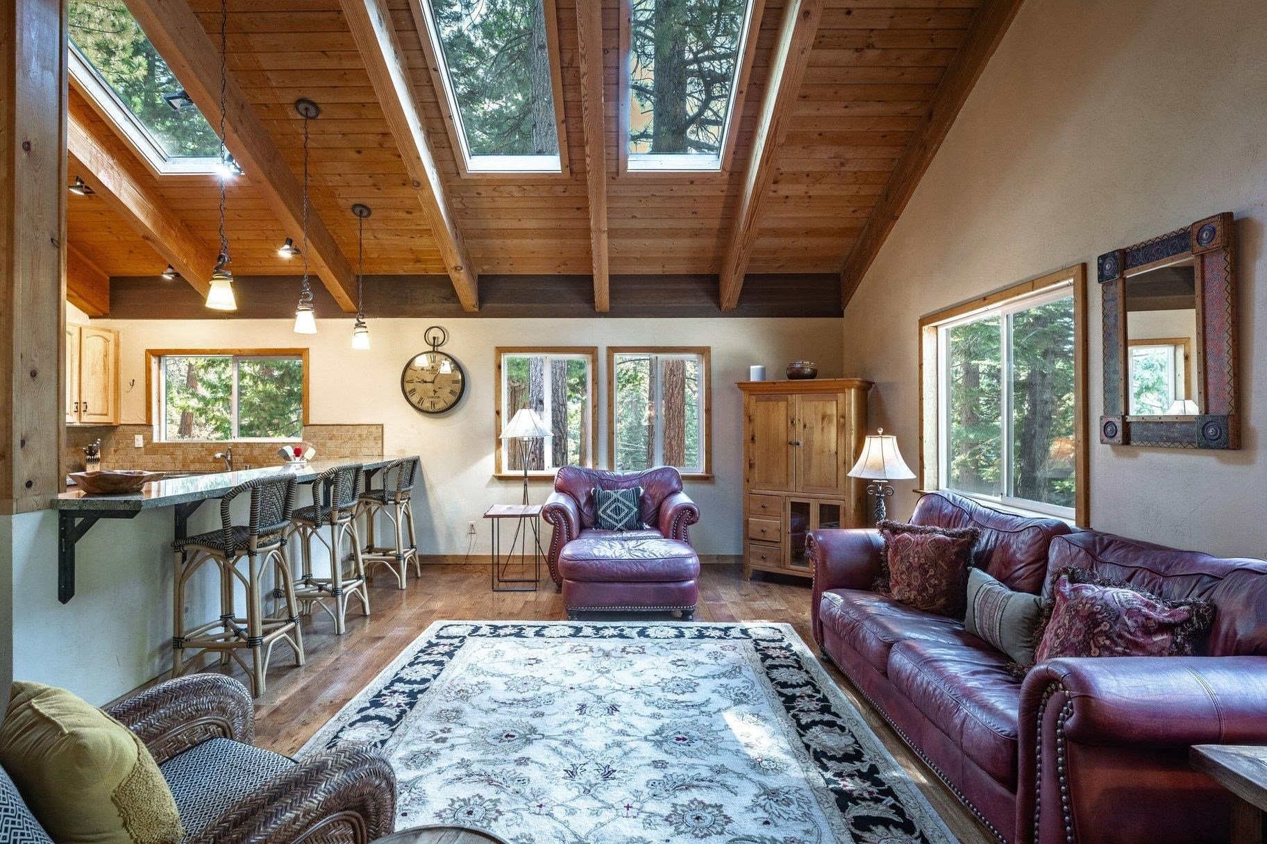 Great room with a vaulted wood ceiling, skylights, leather seating and a kitchen breakfast bar