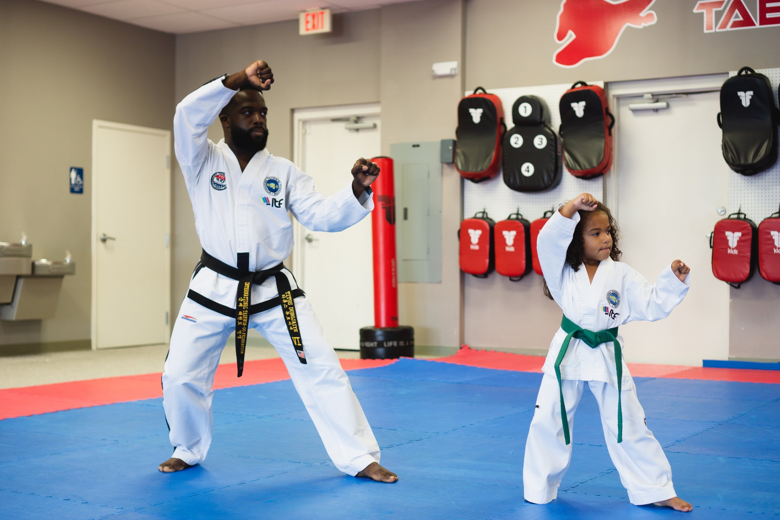 Titus Durojaiye and a young student holding a guarding stance in the dojang
