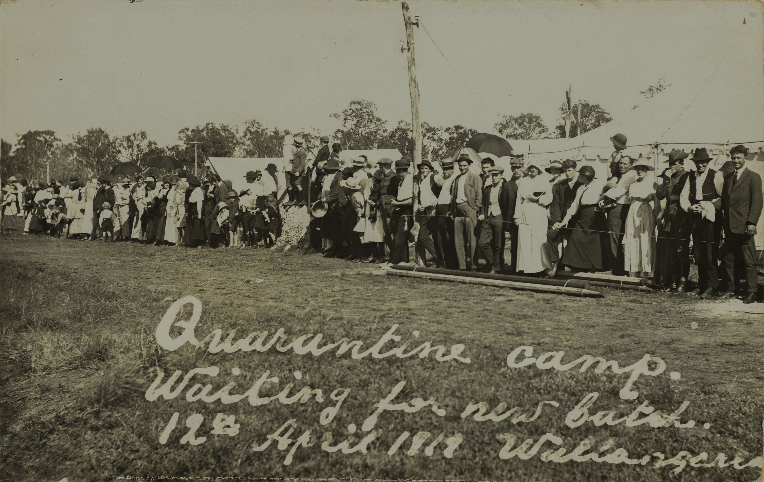 Large number of people waiting at the train station for a new batch of arrivals at the Wallangarra Quarantine Camp, April 1919 SLQ.jpg