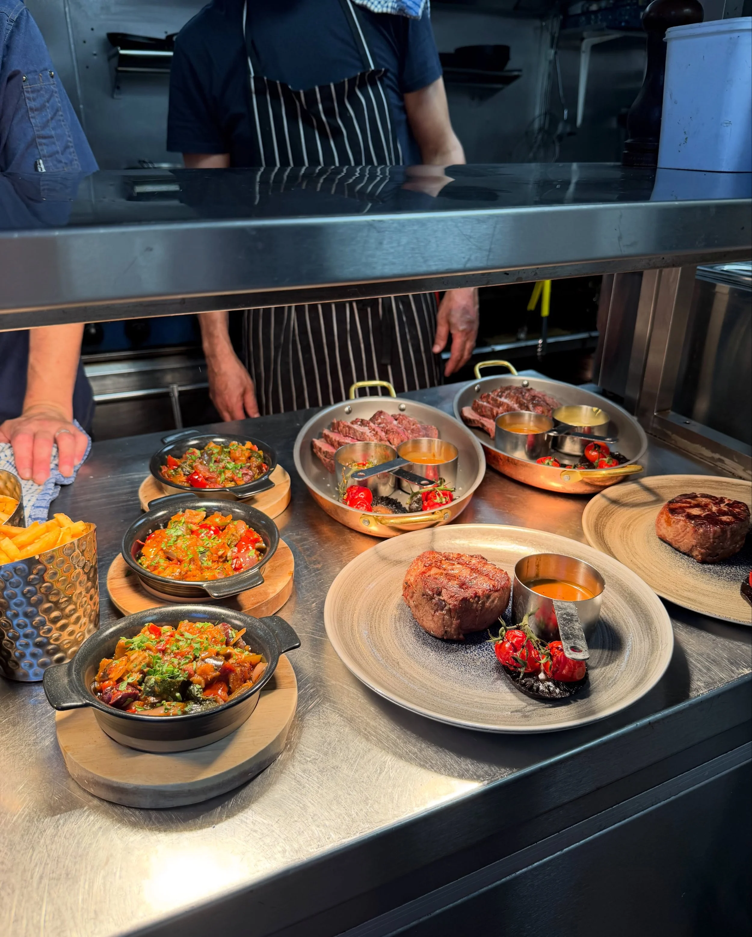 Freshly prepared steaks and colourful vegetable dishes at the Branded Sevenoaks kitchen pass.