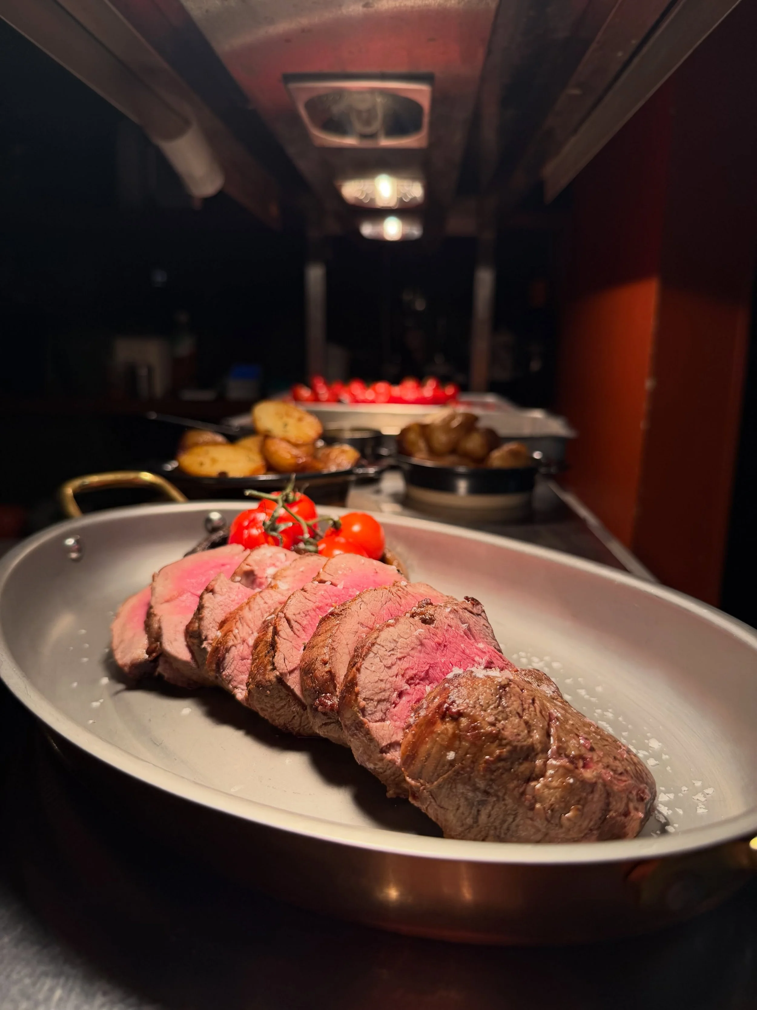 Sliced steak with tomatoes and sides at Branded Beckenham.