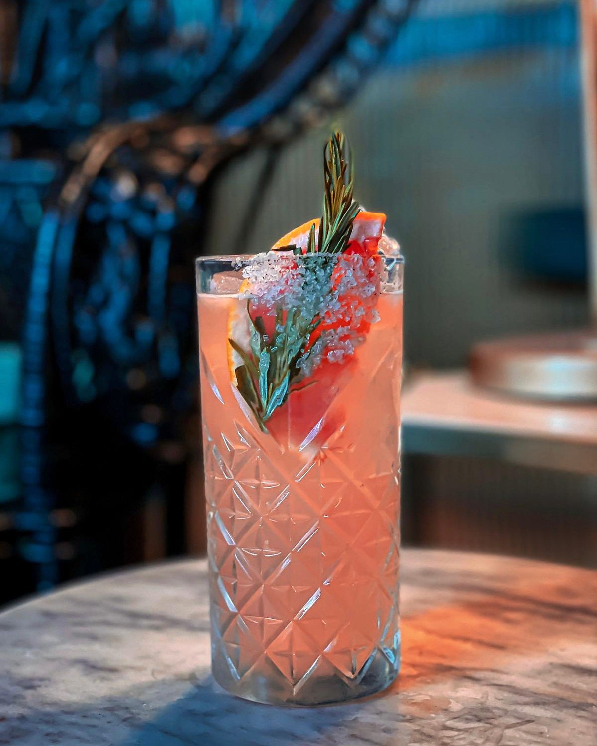Pink cocktail garnished with rosemary at Branded.