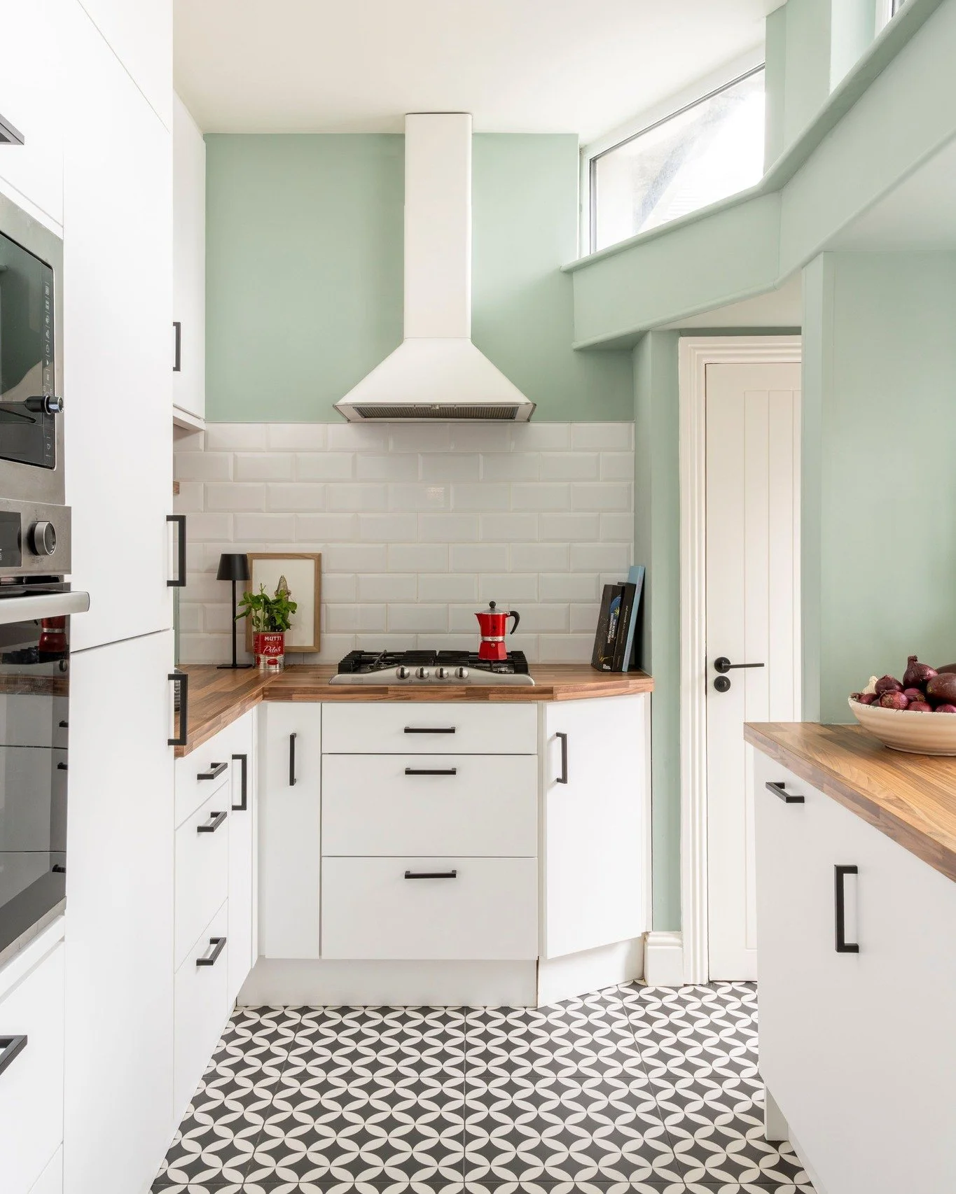The client chose a bright and airy feel in their kitchen in Stoneybatter. We wanted to emphasise the ceiling height and leave the clearstorey windows unobstructed, so chose not to add wall units over the hob. The dark floor was complimented with blac