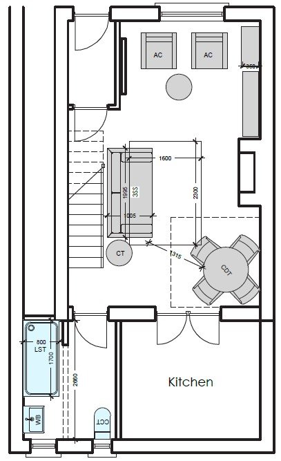A person is drawing or reviewing blueprints or architectural plans, holding a black pen over detailed floor plans on paper.