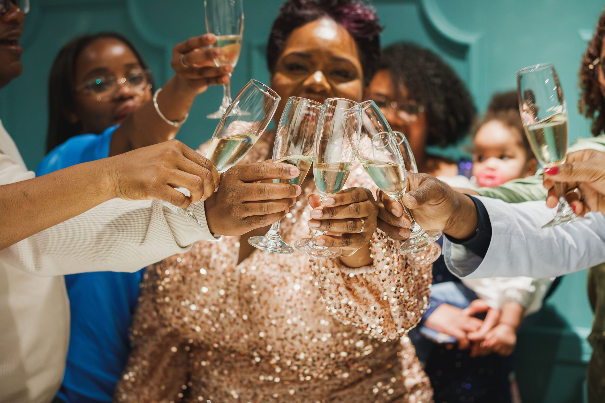 Grupo de pessoas celebrando com taças de espumante em uma comemoração