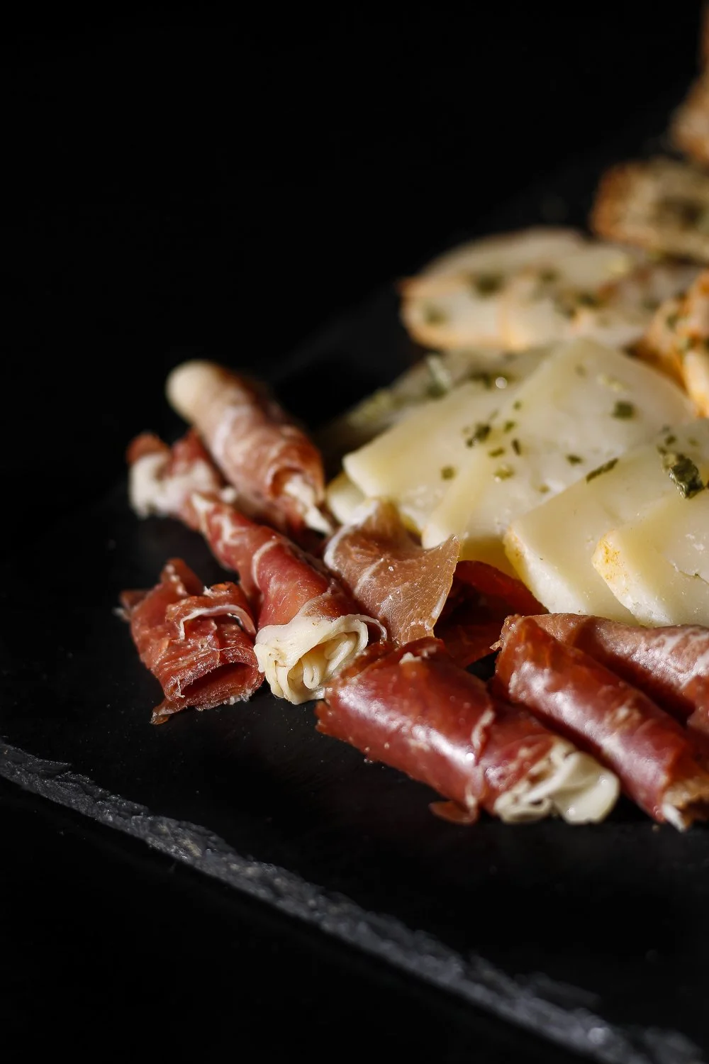Fatias de queijo, presunto e pão em uma chapa de cozinha.
