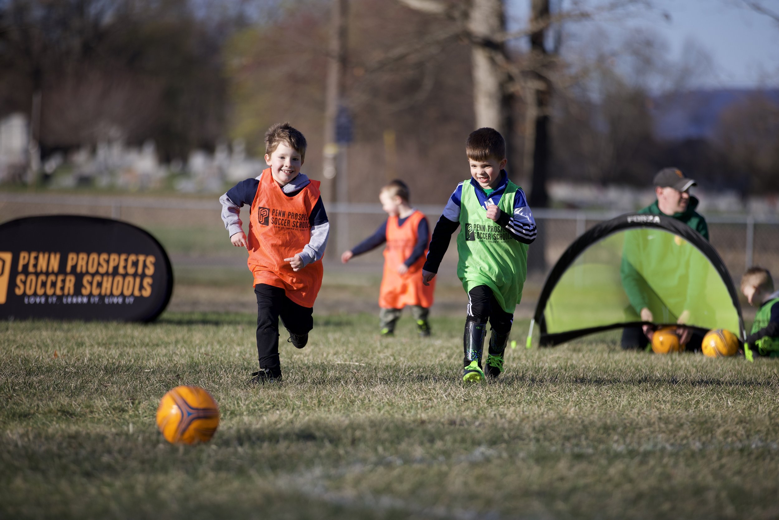 Two young soccer players chasing a ball.