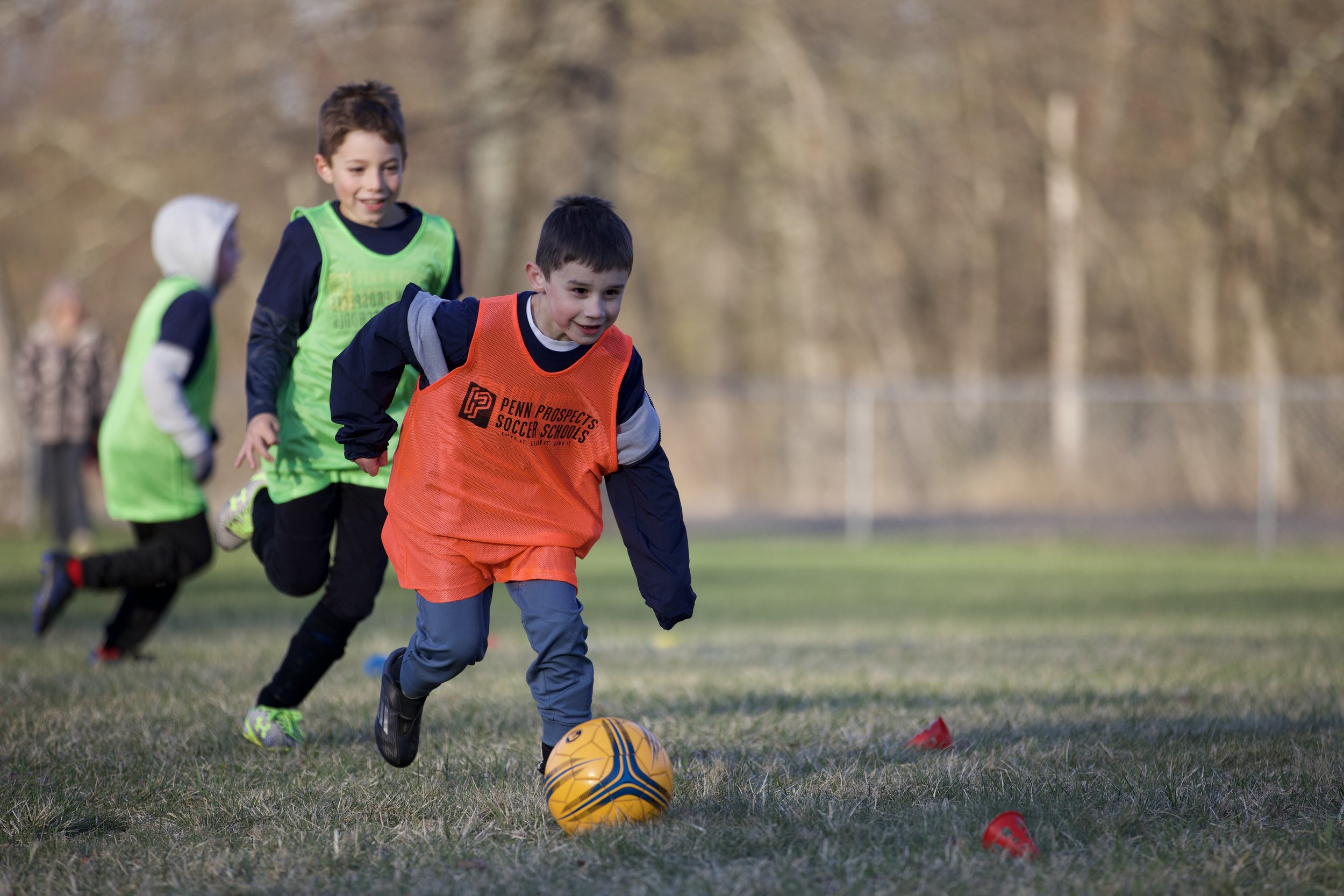 One soccer player chasing another who is dribbling.