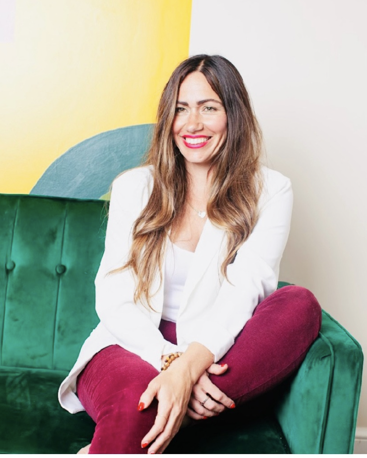 art therapist smiling while sitting on a green coach