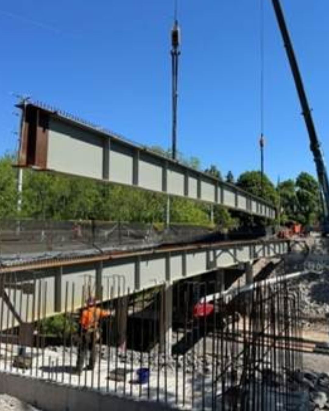 A steel girder is lowered into place