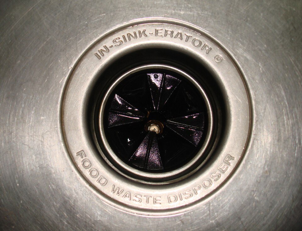 Close-up of an insinkerator food waste disposal unit in a kitchen sink