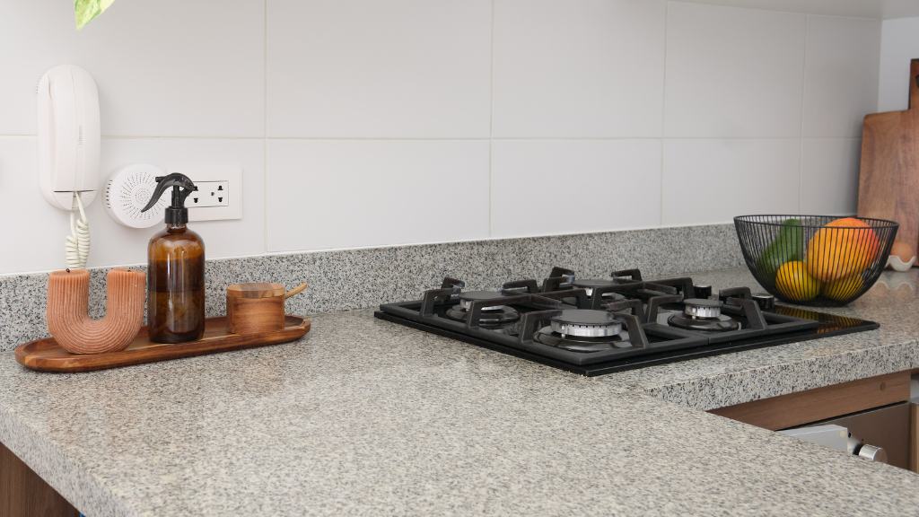 A plumbing setup with a large metal water heater, copper pipes, and various valves and gauges on a plywood wall in a utility room.