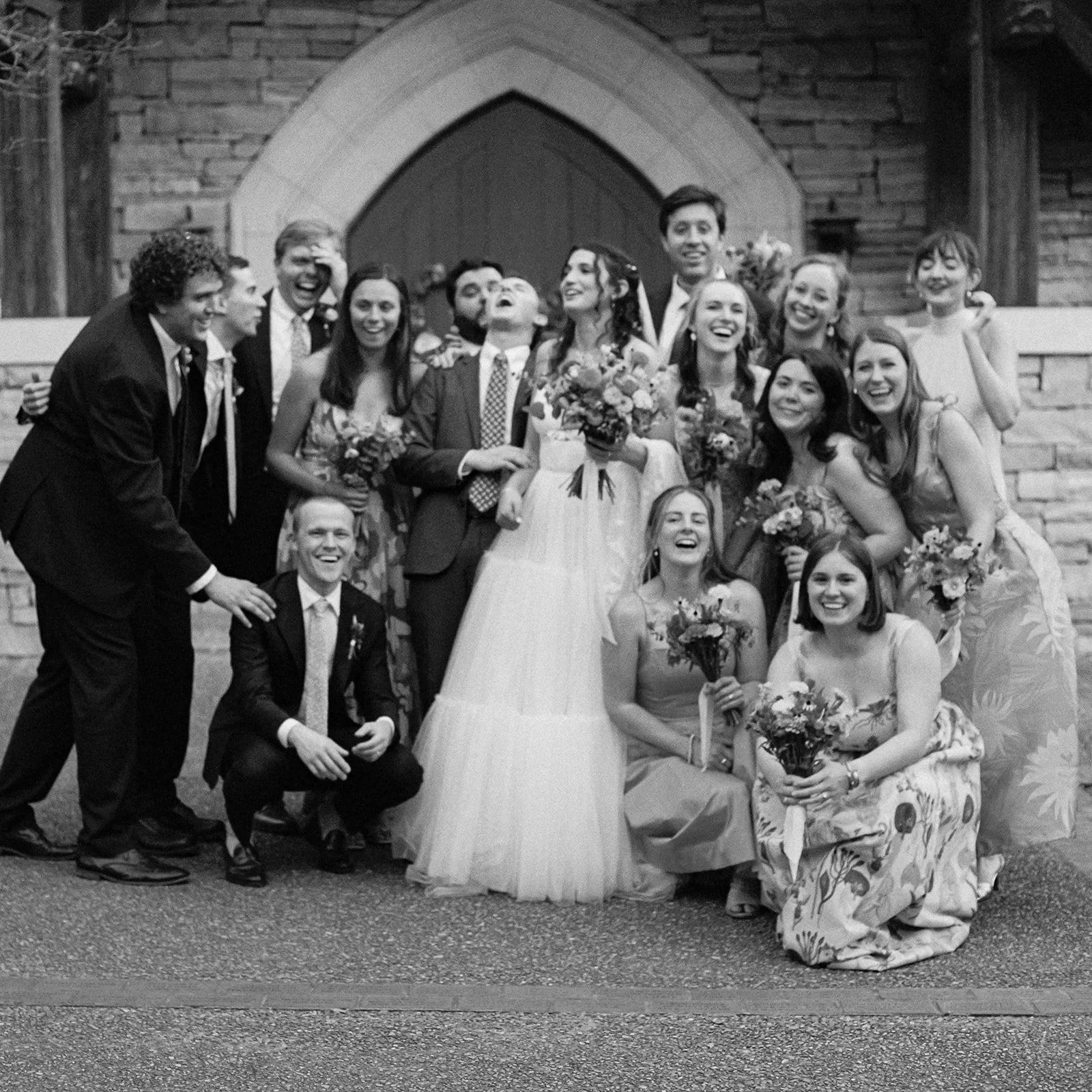 Candid documentary-style wedding party portrait shot on vintage black & white film