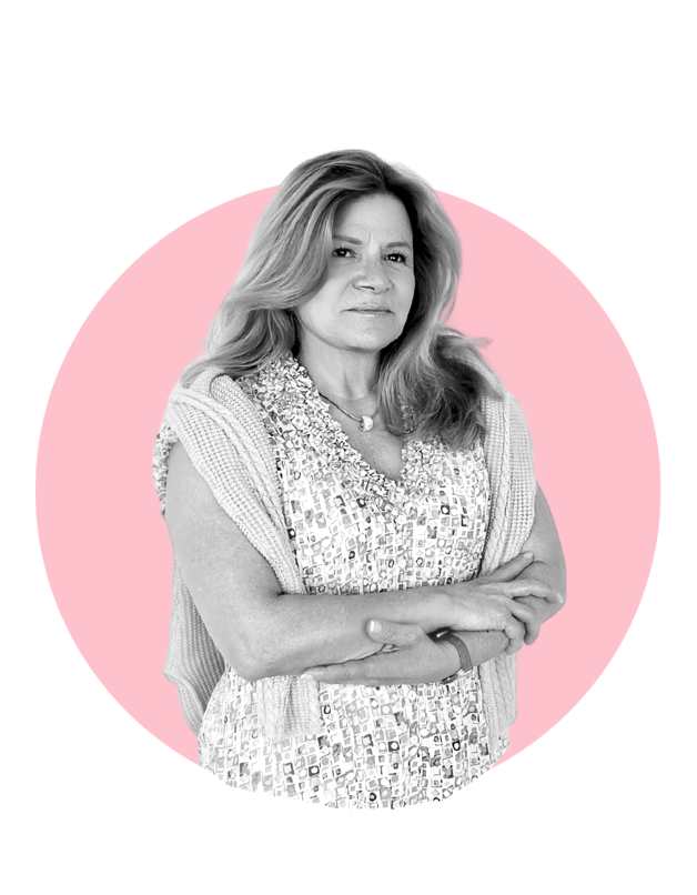 A black and white photo of a distinguished woman standing with her arms folded, against a pink circular background.