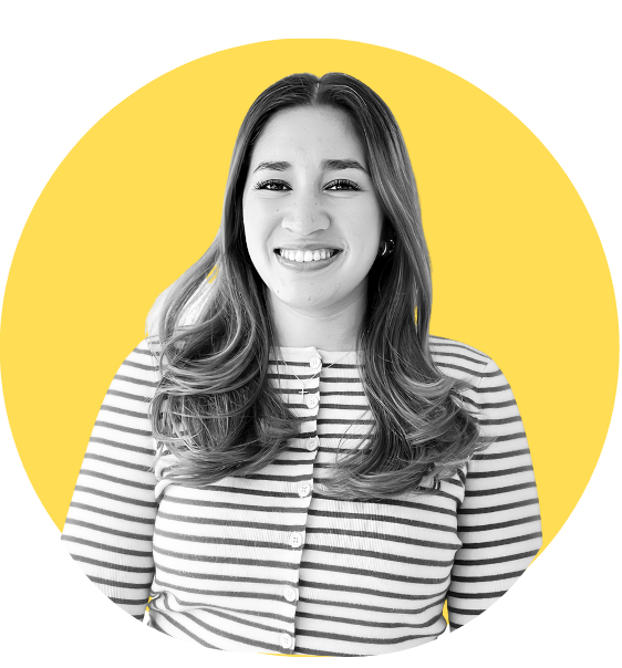 Black and white photo of a smiling woman with long, wavy hair, wearing a striped shirt, set against a yellow circular background.