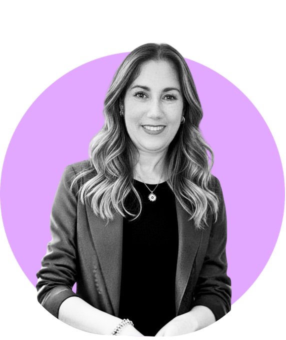 Black and white photo of a smiling woman with wavy hair, wearing a blazer and a necklace, against a purple circular background.