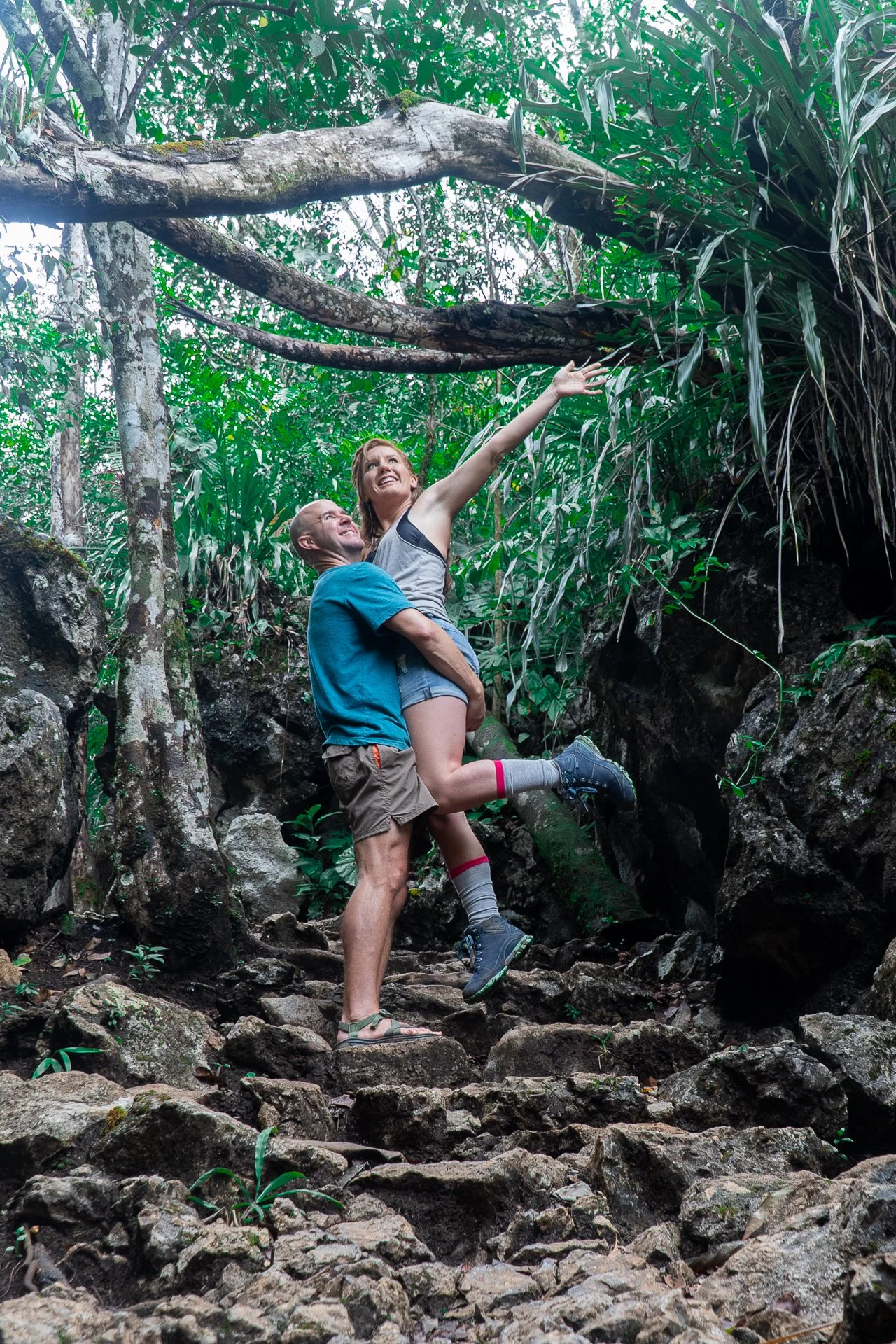 Man holding a happy woman on a trail in Semuc Champey Park in Guatemala