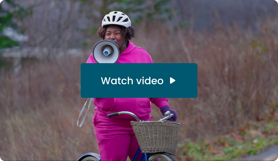 Make Your Move Movement Ambassador Tara Taylor with a megaphone on a bike. Watch video