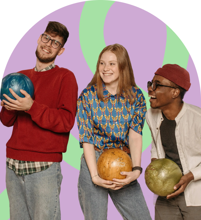 Three friends holding bowling balls