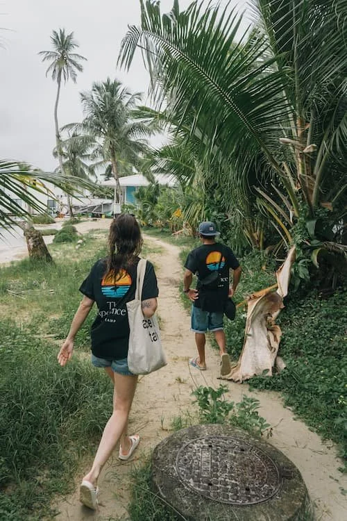 Local guide giving guidance and support for a cool girl as part of the experience surf camp in carenero island in bocas del toro panama