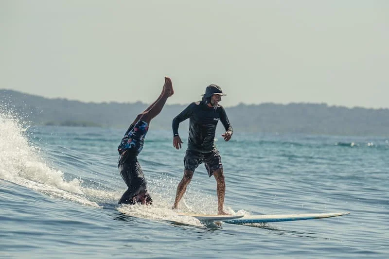Surf instructors taking a wave together and having fun