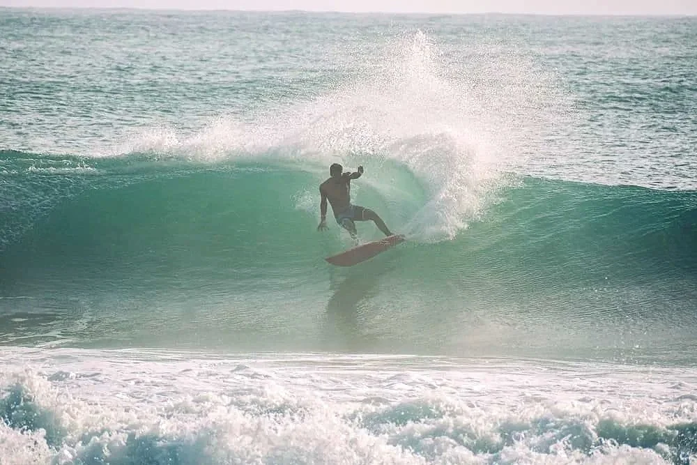 An experienced surfer from The Experience Surf Camp gets barreled in a powerful, turquoise wave in Bocas del Toro.