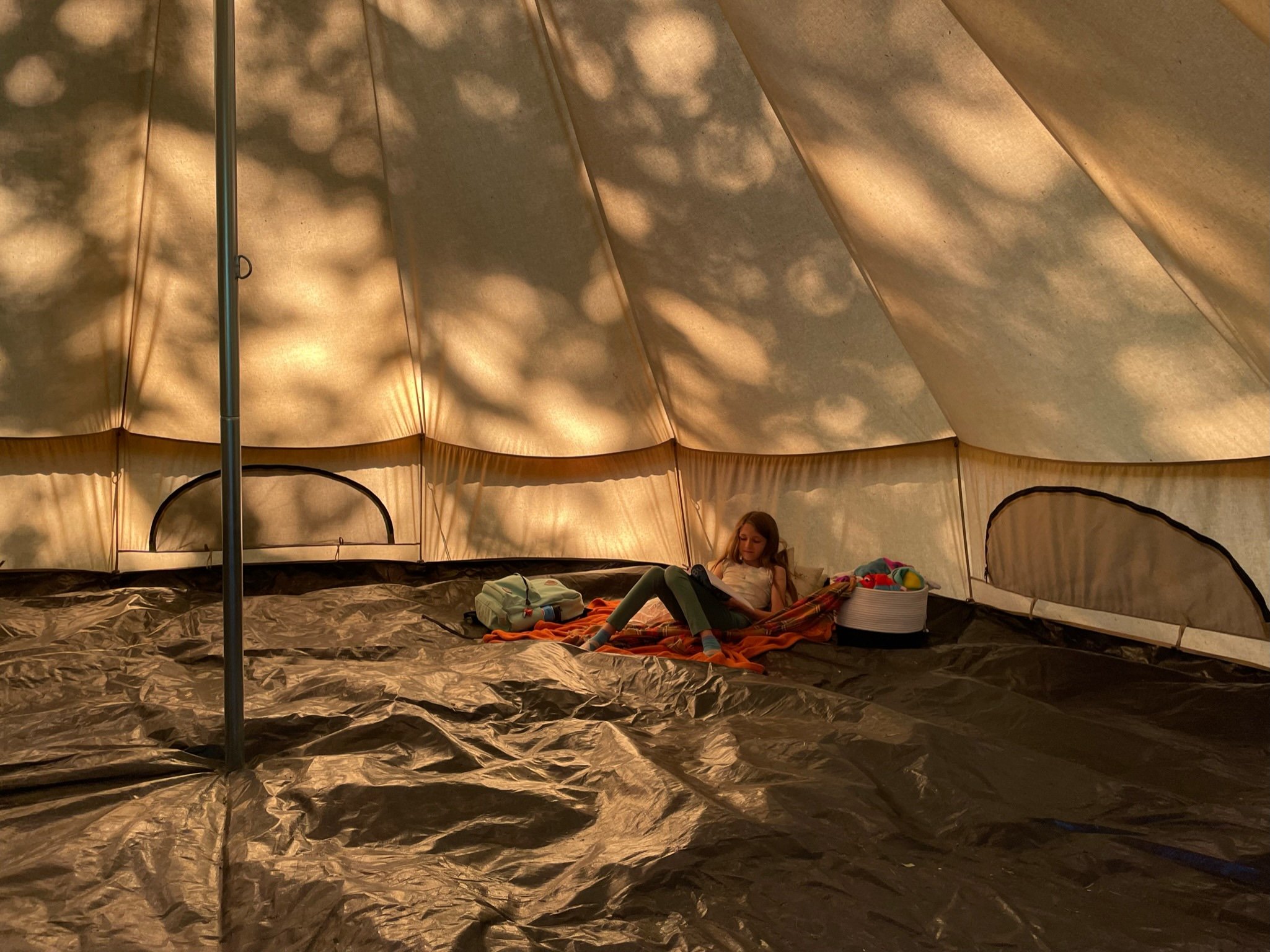 A camper reads in the tent as a quiet and restful reprieve during an active day.