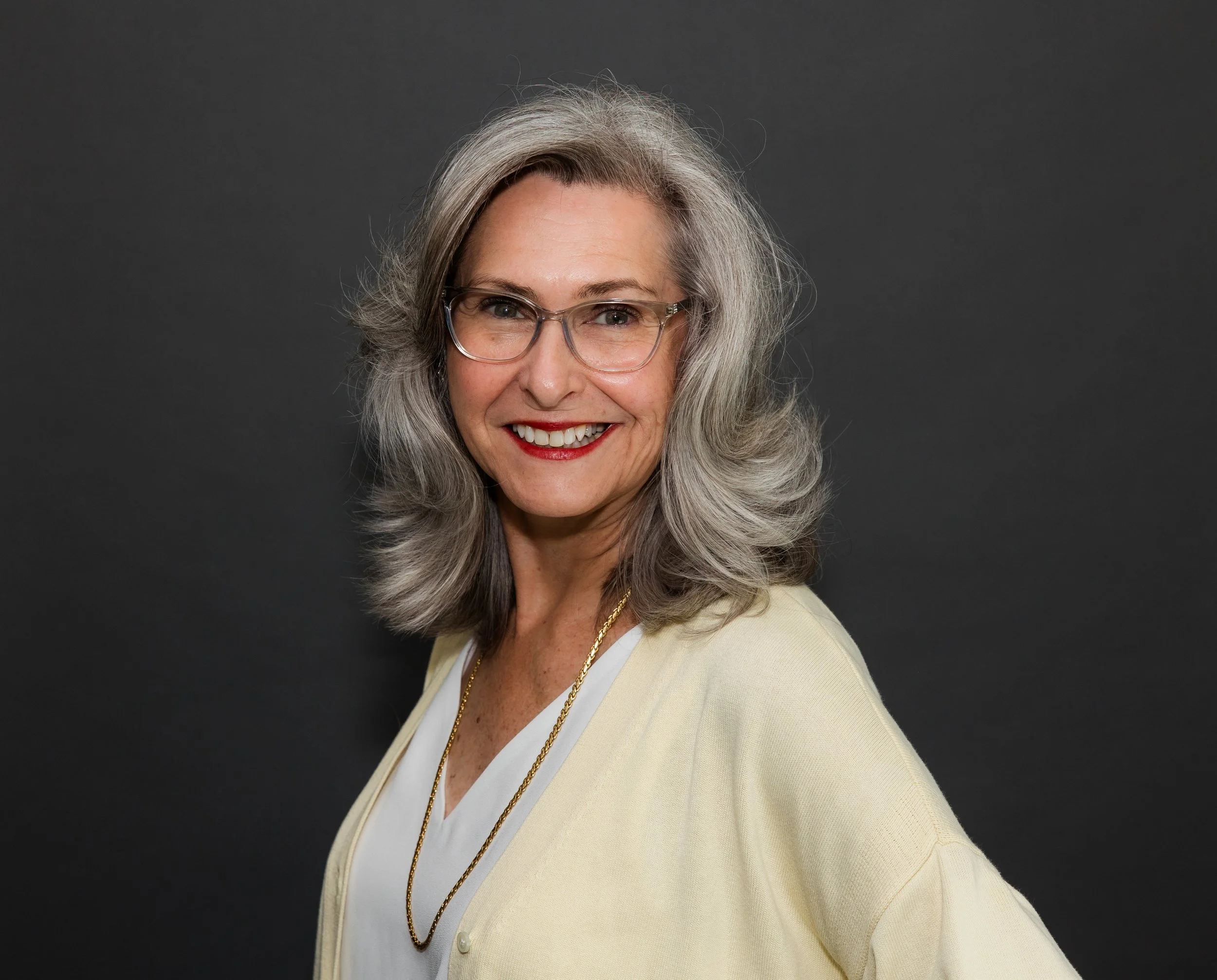 woman grey hair smiling glasses.jpg