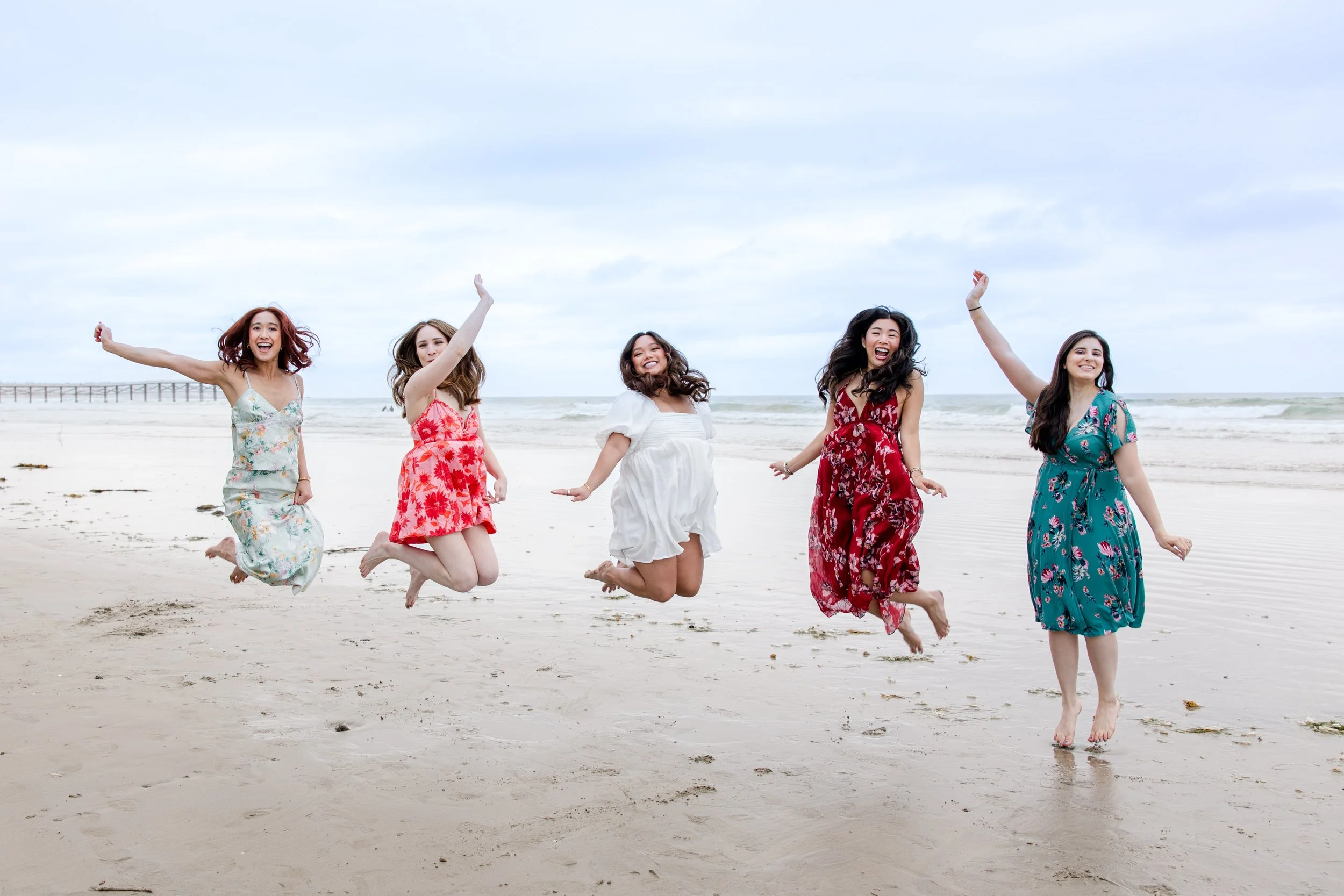 women jumping on sand