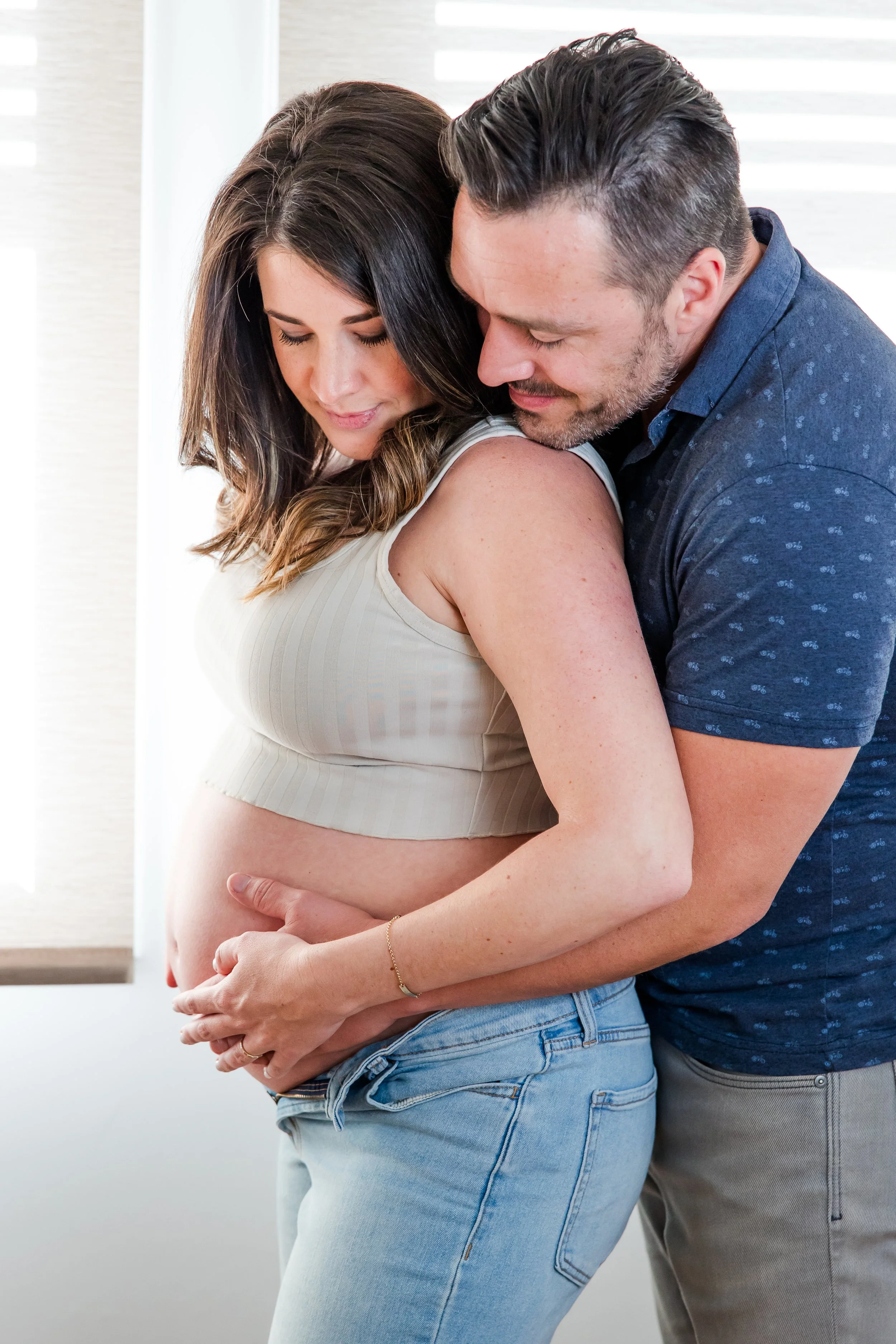 pregnant couple hugging photograph