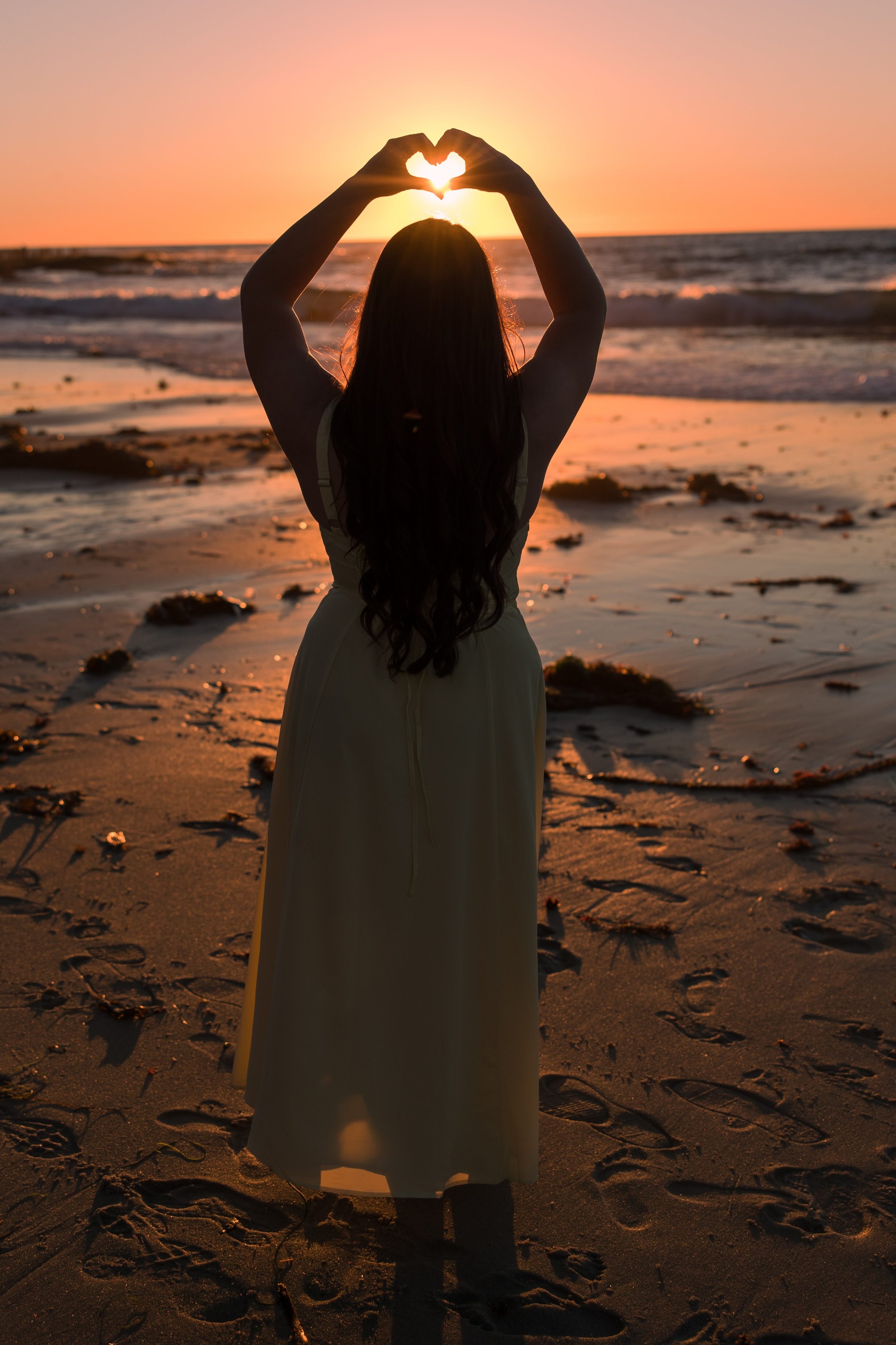 woman-yellow-dress-sunset-beach-heart-hands.jpeg