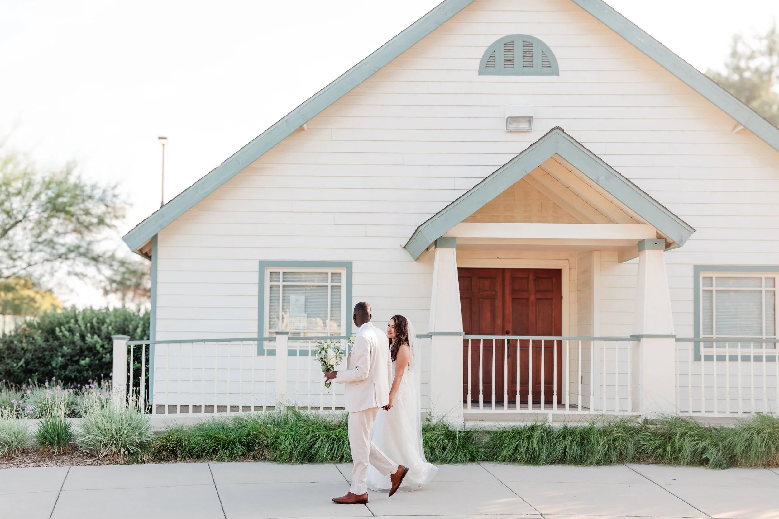 bride-groom-walking-white-church.jpeg